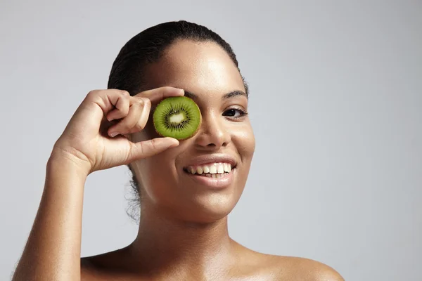 Mujer con rebanada de kiwi —  Fotos de Stock