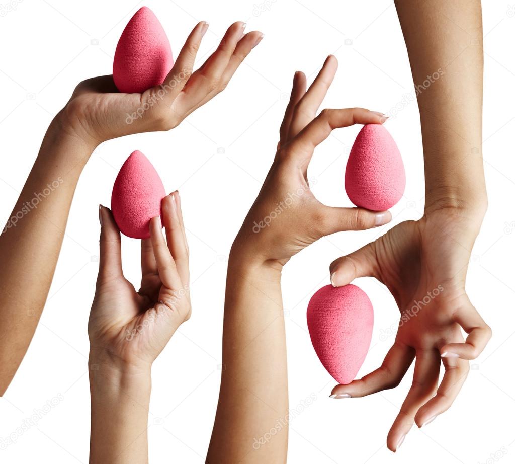 Hands holding makeup sponges
