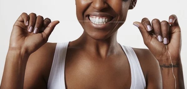 Kvinna rengöring tänderna med tandtråd — Stockfoto