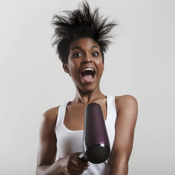 Screaming girl with hair dryer — Stock Photo, Image