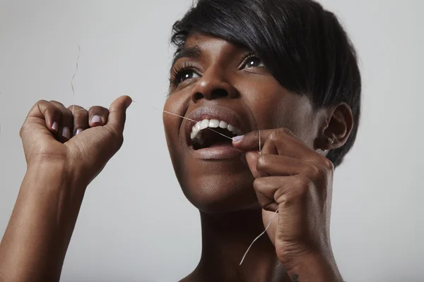 Woman cleaning teeth with dental floss Stock Photo