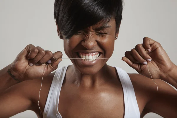 Woman trying to gnaw dental floss — Stock Photo, Image