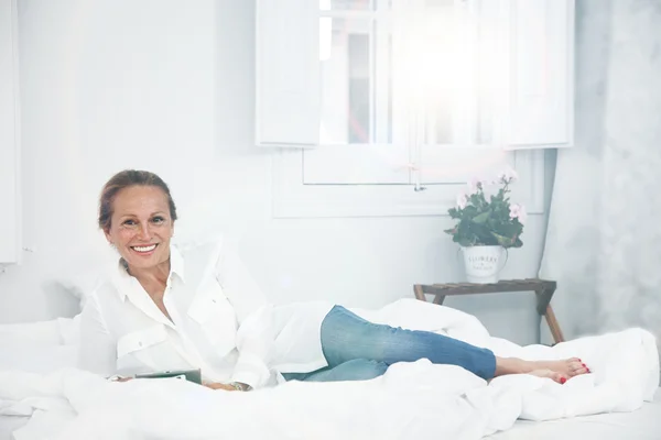 Woman reading in bed — Stock Photo, Image