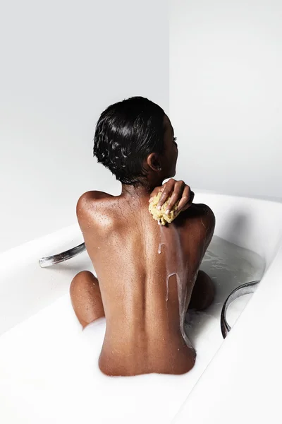 Blck woman in a bath with milk — Stock Photo, Image