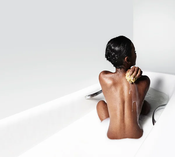 Black woman in white bathroom with milk — Stock Photo, Image