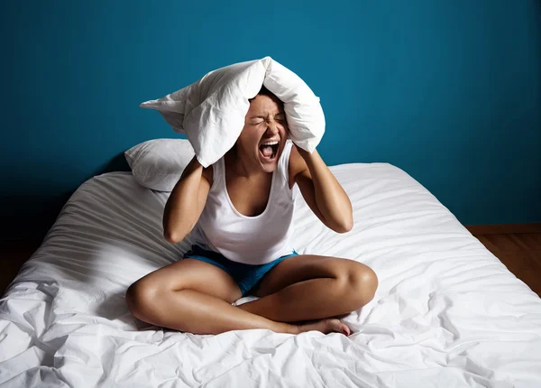 Mujer gritando con almohada en la cabeza —  Fotos de Stock