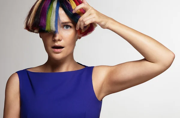Жінка торкається барвистого волосся — стокове фото