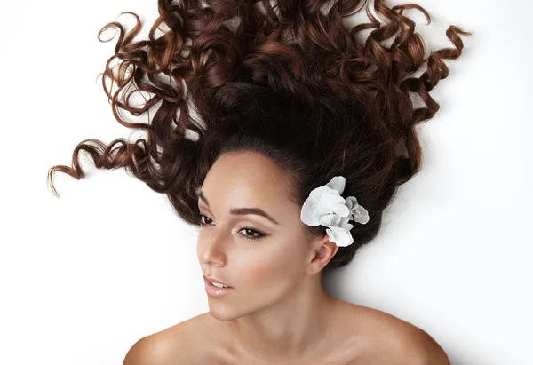 Femme aux cheveux bouclés et fleur — Photo