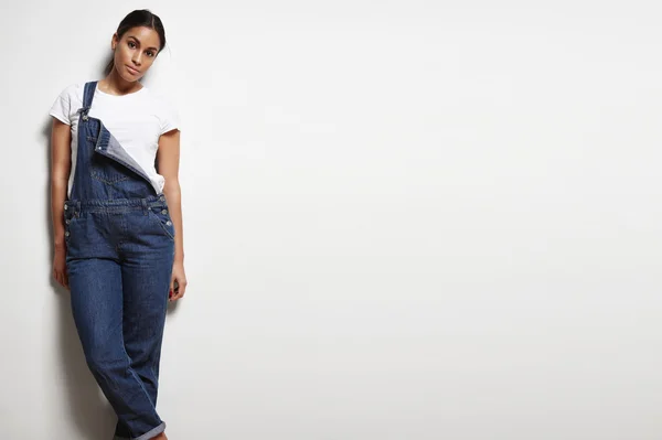 Жінка носить джинсовий комбінезон — стокове фото
