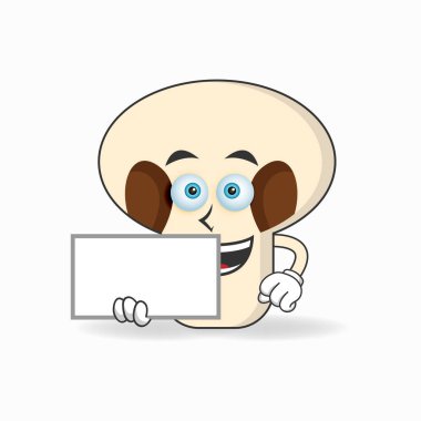 Beyaz bir karatahta tutan mantar maskotu karakteri.