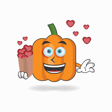 Balkabağı maskotu karakteri bir aşk simgesi tutuyor..