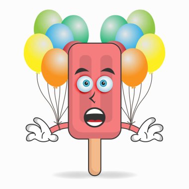 Kırmızı Dondurma maskotu bir balon tutuyor..