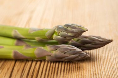 Ahşap arka planda taze kuşkonmaz sürüsü