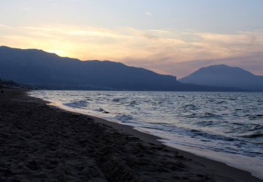 Güneş batarken ön taraftaki denizle birlikte