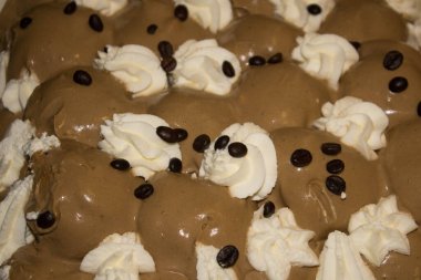 Primo piano di profiterole alla nocciola con panna e chicchi di caff