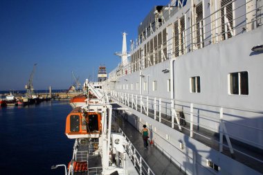 Arkadan gelen insan figürü bir feribotta yelken açmak için bekliyor.