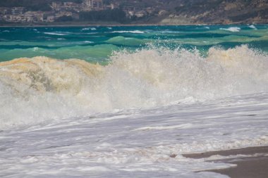 Kumlu bir sahilin canlandırıcı görüntüsü. Bir sürü rengi ve berrak gökyüzü var.