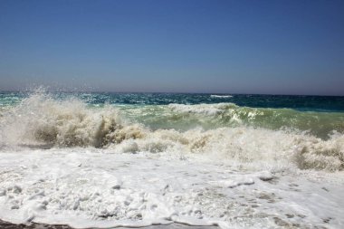 Kumlu bir sahilin canlandırıcı görüntüsü. Bir sürü rengi ve berrak gökyüzü var.