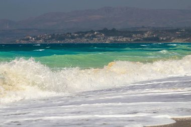 Kumlu bir sahilin canlandırıcı görüntüsü. Bir sürü rengi ve berrak gökyüzü var.