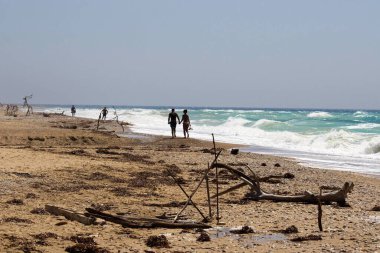 Kumlu bir sahilin canlandırıcı görüntüsü. Bir sürü rengi ve berrak gökyüzü var.