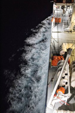 Feribotun kenarından gece su izinin canlandırıcı görüntüsü.