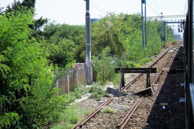 Milan, İtalya - 10 Ağustos 2020 hareket halindeki trenin penceresinden: Milan-Genova rotasındaki raylar ve doğal manzara