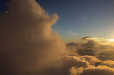 Önünde ve uzağında bulutlar olan bir uçaktan görülebilen muhteşem bir gün batımı.