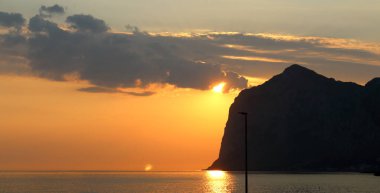 Güneşin ufukta doğuşuyla birlikte denizin üstünde güneşin doğuşunun canlandırıcı görüntüsü.