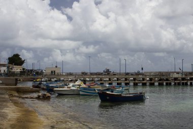 İtalya 'nın Sicilya kentindeki küçük bir balıkçı köyünde demirlemiş balıkçı teknelerinin canlandırıcı görüntüsü.