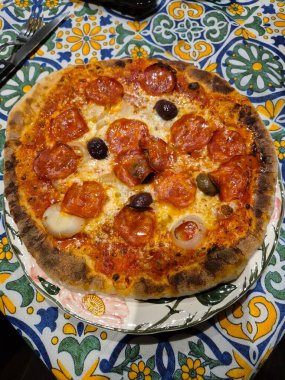 Baharatlı salam, domates sosu, mozarella, soğan ve zeytinli ev yapımı pizzanın anımsatıcı görüntüsü..