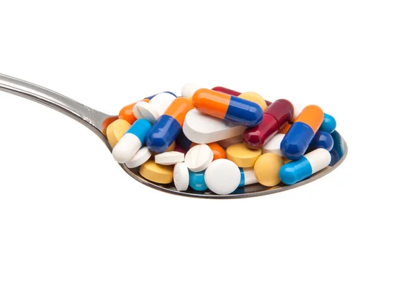 Tabletták és kapszulák egy kanál Stock Kép