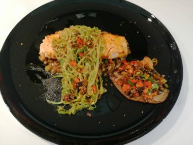 Tahta masada patates ve sebzeli kızarmış somon bifteği.