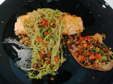 Tahta masada patates ve sebzeli kızarmış somon bifteği.