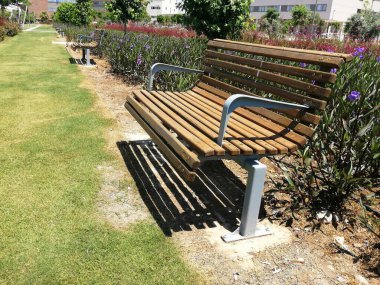 Güzel bir park bahçesinde iki ahşap bank.