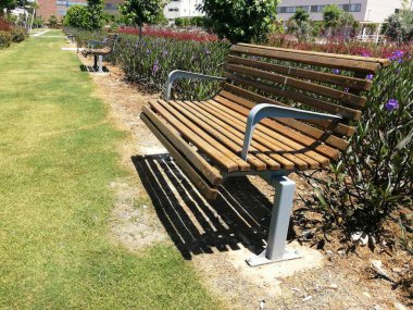 Güzel bir park bahçesinde iki ahşap bank.