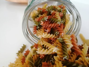 Cam kavanozdaki çeşitli çiğ makarna.