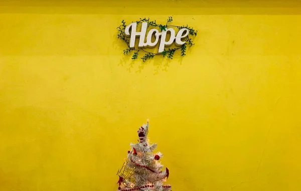 Fehér Szó Remény Zöld Levél Van Csatolva Sárga Fal Tetején — Stock Fotó