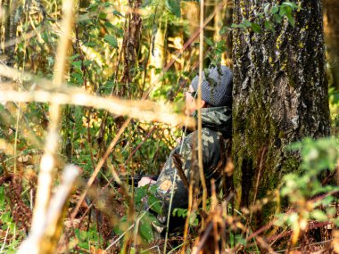 Avcı ağaç gövdesine oturup avını, avını ve avını bekler. Av sezonu ve av hayvanlarının açılışını yapar.