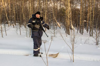 Avcı ormandaki izleri gösteriyor.