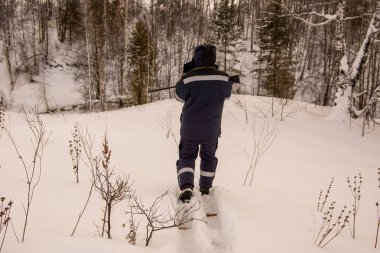 Kayak yapan avcı, derenin karla kaplı yamacına yaklaştı.