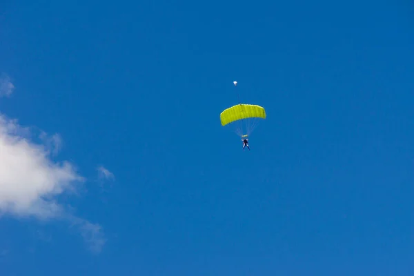 Tandem jump with green parachute-wing — Stock Photo, Image