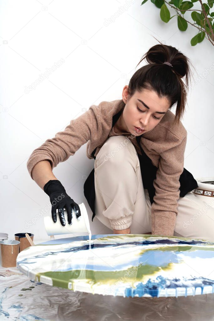 A young woman creates a painting using liquid art technique