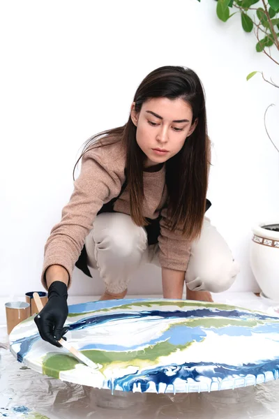 Une jeune femme crée une peinture en utilisant la technique de l'art liquide — Photo