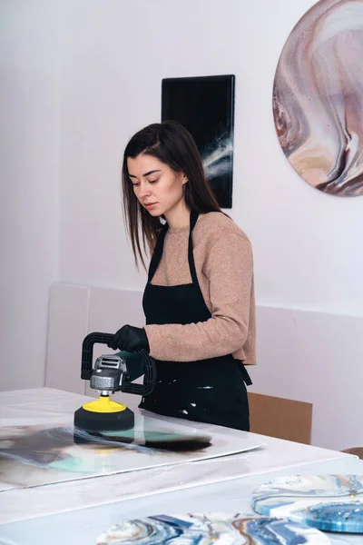 A grinding machine in the hands of a young woman artist. — Stock Photo, Image