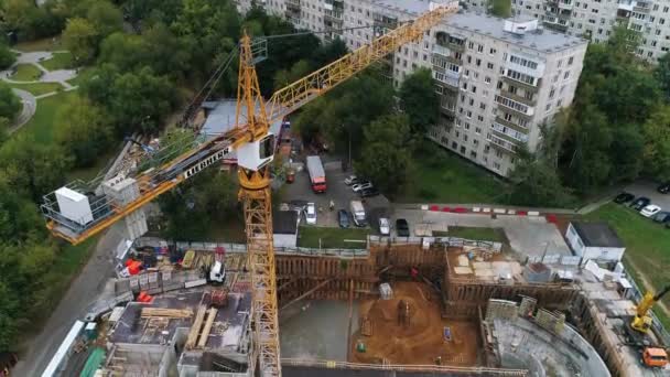 Vysoký jeřáb pracuje na staveništi s domem - záběry dronů — Stock video