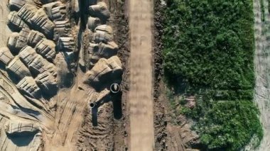 Bir silindir ve kazıcı kullanarak bir yol inşa etmek - helikopter görüntüsü