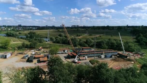 Equipo de construcción pavimentando una nueva carretera y puente a través del arroyo - imágenes de drones — Vídeo de stock