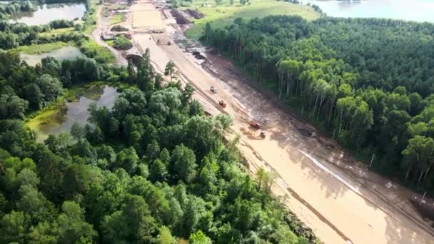 Construcción de una nueva carretera a través del parque de la ciudad. Camiones volquete mineros. Imágenes de drones — Vídeos de Stock