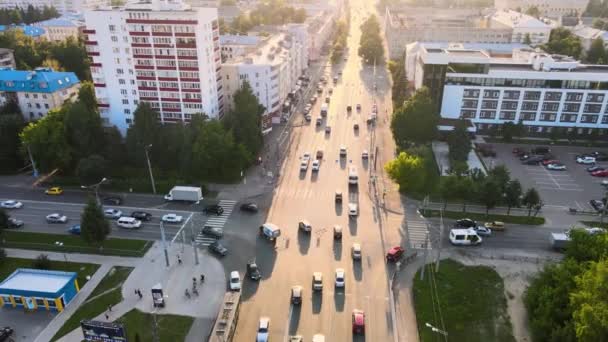 지는 태양이 내리쬐는 도시의 교차로. 드론 영상 — 비디오