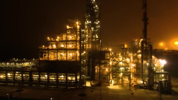 Fliegen entlang der Ölraffinerie in einer nebligen Nacht mit heller Nacht goldenes Licht — Stockvideo